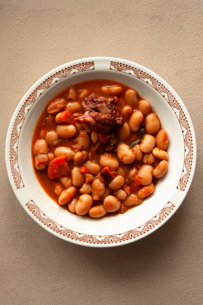 A bowl of savory baked beans with meat in rich tomato sauce, perfect for comfort food lovers.