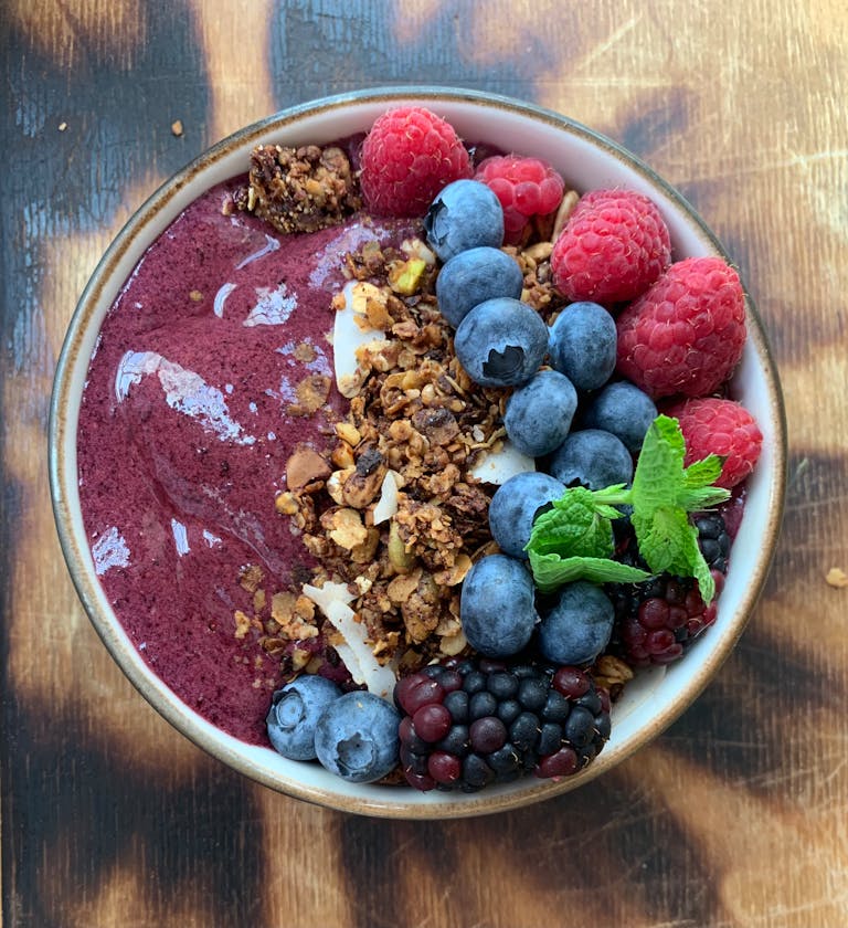 Top view of delicious acai bowl with fresh berries and granola, perfect for healthy eating.
