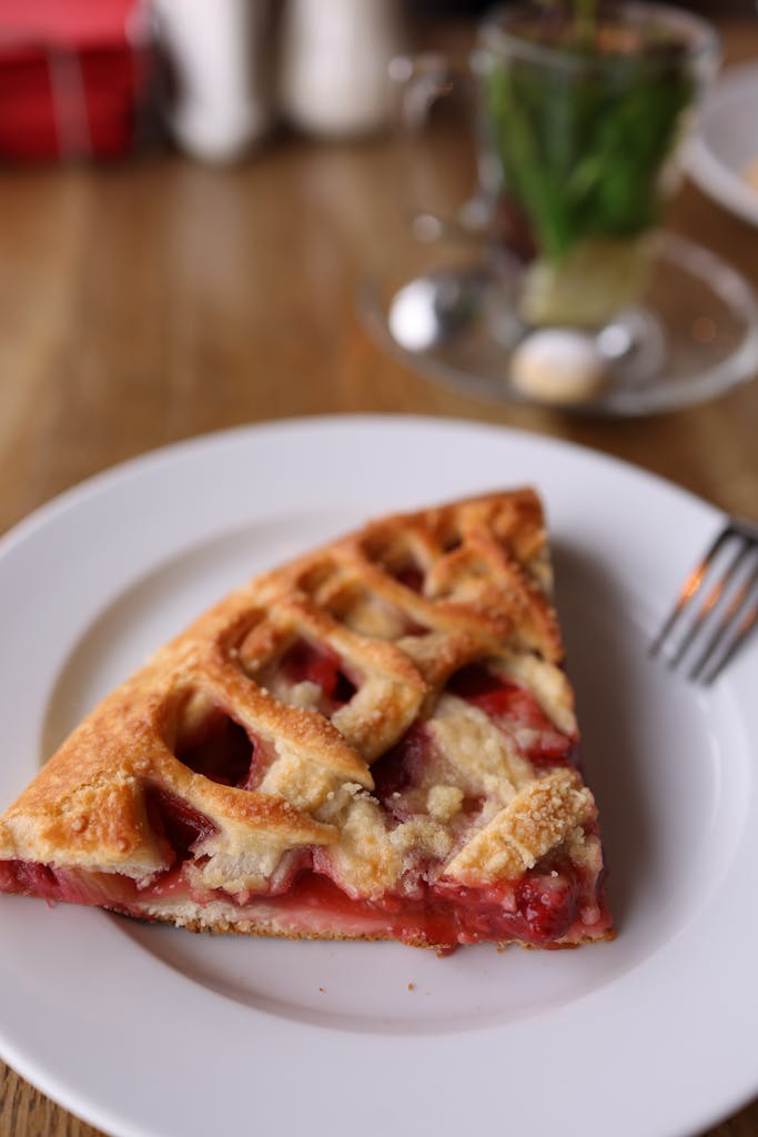 Close-up of a delicious strawberry pie slice served on a white plate.