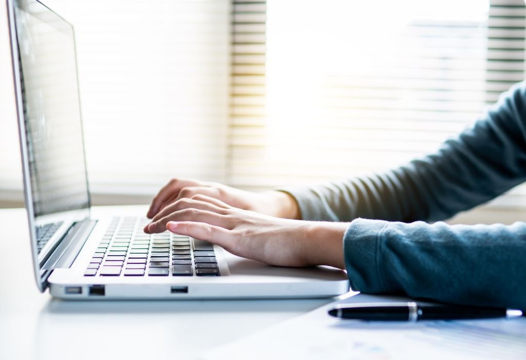 Close-up shot of hands typing on a laptop keyboard, perfect for business or technology themes.
