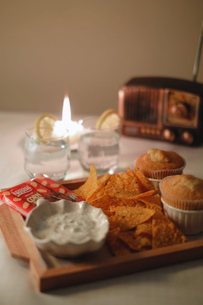 A warm indoor setting with snacks, drinks, and ambient lighting.